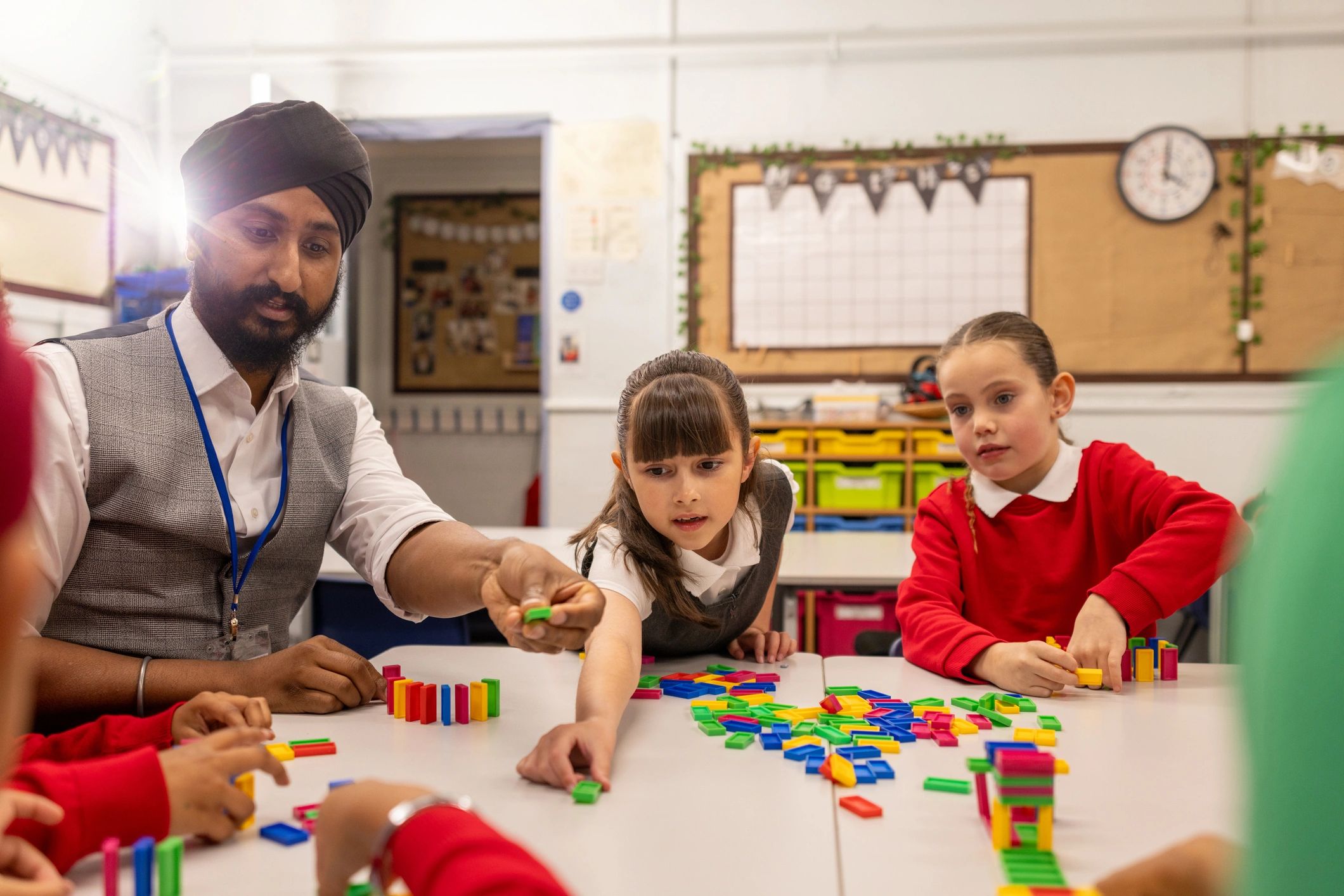 Children gathered around a table during guided building play